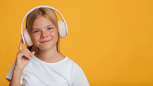 Leende europeisk tonåring flicka i vit t-shirt och trådlösa hörlurar lyssna musik eller lektion online — Stockfoto