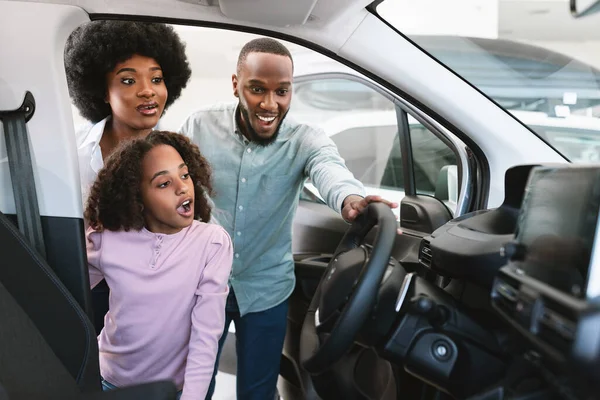 ディーラーで新しい自動車を選択し、車のサロンを見て興奮した黒人家族は、スペースをコピーします — ストック写真