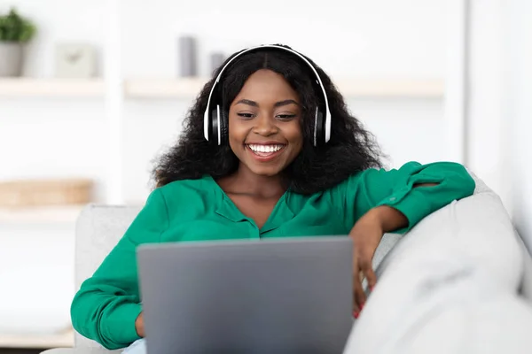 Sonriente mujer negra disfrutando de fin de semana en casa, viendo películas en línea — Foto de Stock