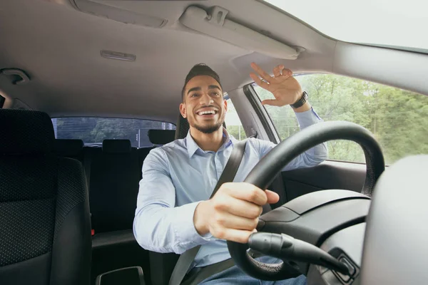 Alegre médio-oriental cara dirigindo auto, cumprimentando alguém — Fotografia de Stock