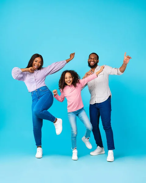 Retrato de família negra emocional dançando no estúdio azul — Fotografia de Stock