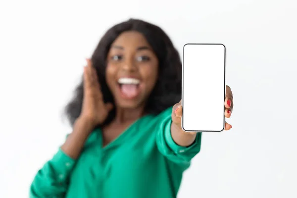 Emocional mujer negra mostrando el teléfono celular con pantalla en blanco — Foto de Stock