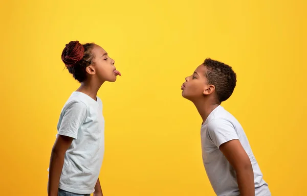 Stygga svarta bror och syster som bråkar, visar tungor — Stockfoto