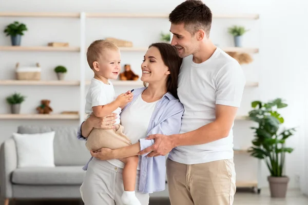Ritratto di giovani genitori felici in posa con il loro bambino figlio a casa — Foto Stock