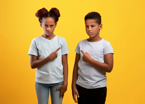 Arg svart bror och syster pekar på varandra — Stockfoto