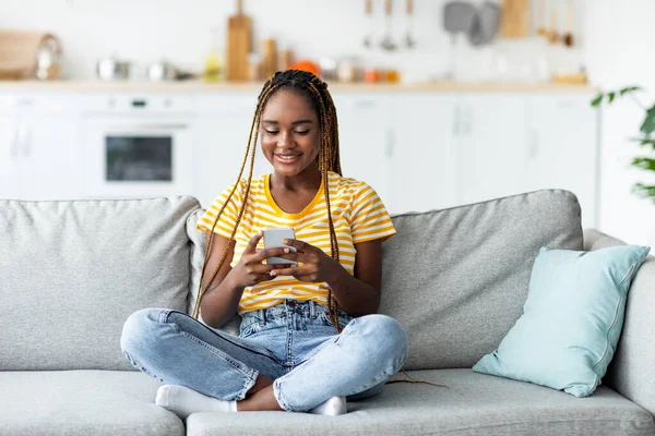 Linda dama afro-americana usando teléfono móvil en casa —  Fotos de Stock