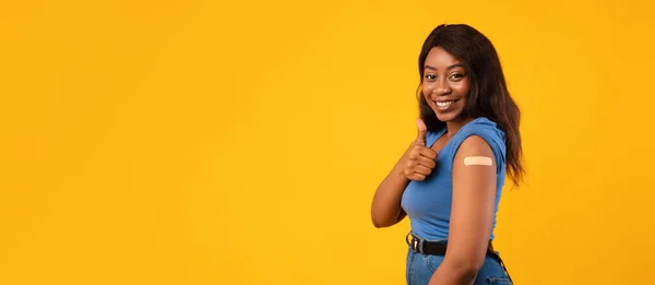 Vaccinato afro-americano donna gesturing Pollici-Up approvazione vaccino, sfondo giallo — Foto Stock