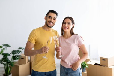 Irklar arası eşleri sevmek taşınma gününü şampanyayla kutlamak, yeni dairede karton kutuların arasında kadeh kaldırmak.