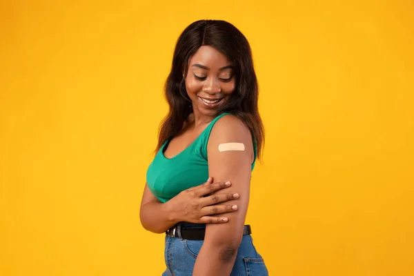 非洲裔美国妇女接种Covid-19疫苗显示胳膊黄色背景 — 图库照片