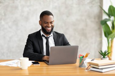 Klavyede dizüstü bilgisayar kullanan Afrikalı Amerikalı bir adam