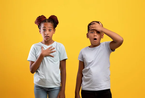 Geschokt afrikaanse amerikaanse broer en zus op geel — Stockfoto