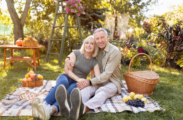 Feliz pareja de ancianos descansando en el parque de otoño, teniendo picnic y sonriendo a la cámara, espacio para copiar —  Fotos de Stock