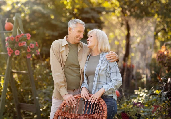 Happy senior retired couple embracing, resting in countryside and looking at each other with love — Stock Photo, Image