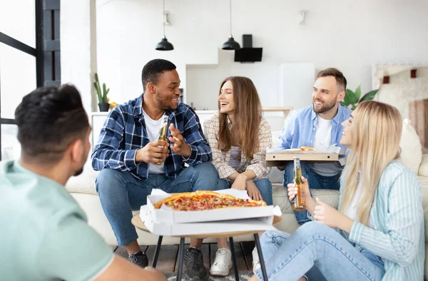 Groep gelukkige interraciale vrienden die feesten, pizza eten, bier drinken, thuis iets vieren — Stockfoto