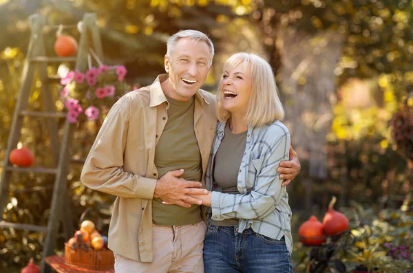 Concepto de vida familiar. Feliz pareja de ancianos caminando y riendo en el jardín al aire libre, disfrutando del tiempo juntos —  Fotos de Stock