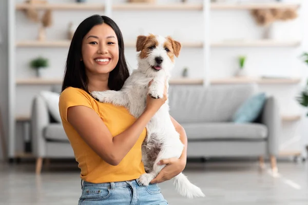 Porträtt av glad asiatisk kvinna som bär sin söta hund — Stockfoto