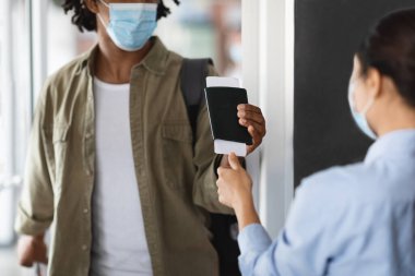 Siyah Maskeli Gezgin 'in pasaportu ve biletleri havaalanında kontrol ediliyor.