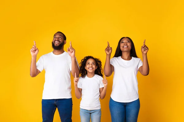 Glimlachende zwarte familie wijst naar gratis kopieerruimte — Stockfoto