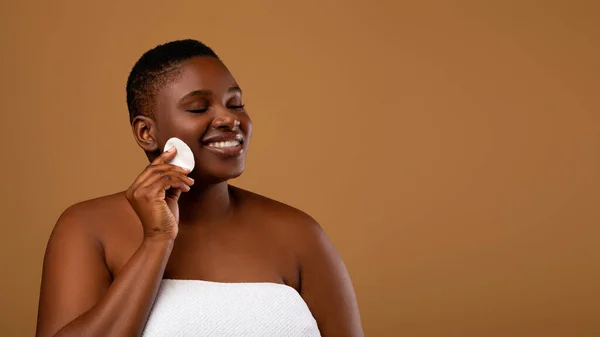 Portrait of curvy black woman cleaning skin by cotton pad — Stok Foto
