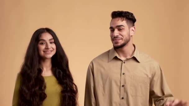 Feliz pareja de Oriente Medio Gestos OK a la cámara sobre fondo beige — Vídeo de stock