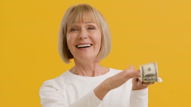 Riqueza y prosperidad. Mujer rica mayor lanzando billetes de dinero y riendo — Vídeo de stock
