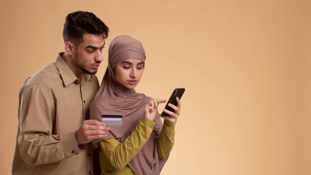 Muslimisches Paar hat Probleme mit Telefon und Kreditkarte — Stockvideo