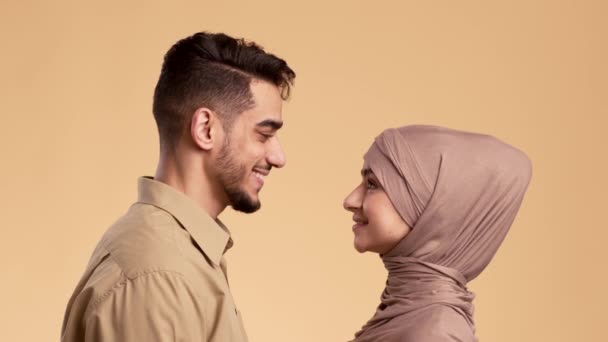 Pasangan Muslim Dalam Cinta Tersenyum Satu sama lain Selama Beige Latar Belakang — Stok Video