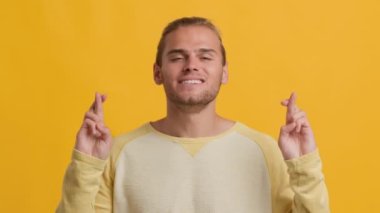 Dilek tutuyorum. Pozitif Genç Sarışın Adam Parmaklarını çapraz yapıp 