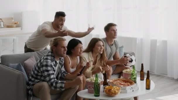 Emocjonalne Multiethnic Przyjaciele oglądać mecz piłki nożnej w domu i dopingować Ulubiony zespół — Wideo stockowe