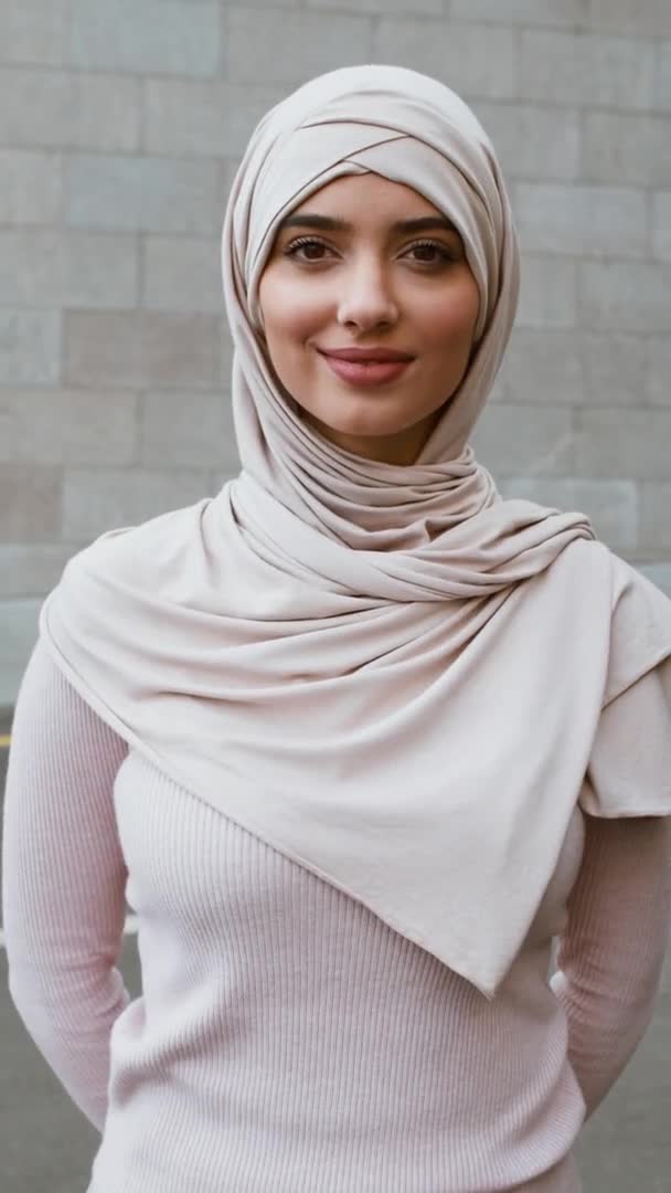 Vertikales Porträt einer jungen Frau aus dem Mittleren Osten, die einen Hijab trägt, lächelnd in die Kamera lächelt und im Herbst im Freien posiert — Stockvideo