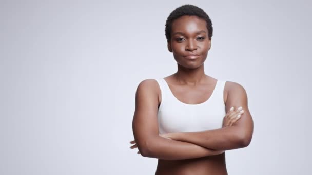 Concepto de confianza en sí mismo. Joven mujer afroamericana confiada cruzando sus manos y sonriendo a la cámara, espacio vacío — Vídeo de stock