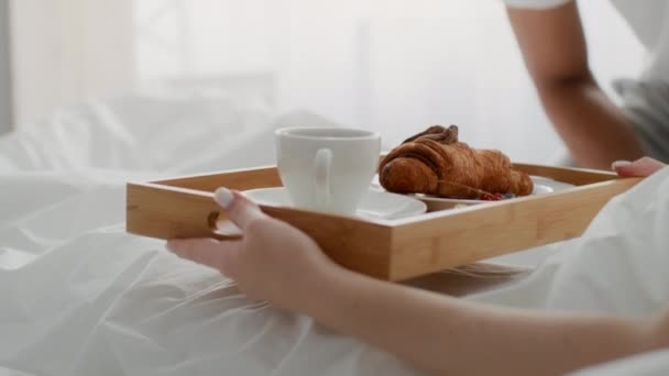Almuerzo romántico en la cama. irreconocible afroamericano novio trayendo bandeja con desayuno a su despertar novia — Vídeo de stock