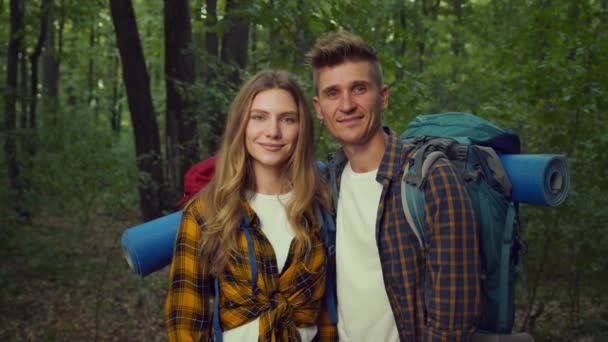 Terapia marital natural. Primer plano retrato de feliz pareja con mochilas y equipo de camping sonriendo a la cámara — Vídeo de stock