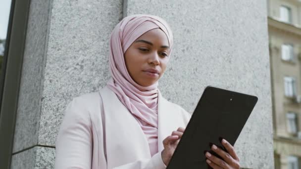 Современный бизнес. Молодая уверенная африканская деловая леди работает над цифровым планшетом, составляя план проекта онлайн — стоковое видео