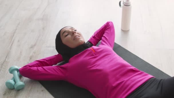 Abs workout. Top view at young motivated muslim woman wearing traditional headscarf practicing crunches exercise — Stock Video