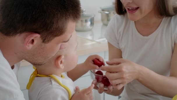 Adorabile bambino che mangia snack con i genitori in cucina insieme — Video Stock