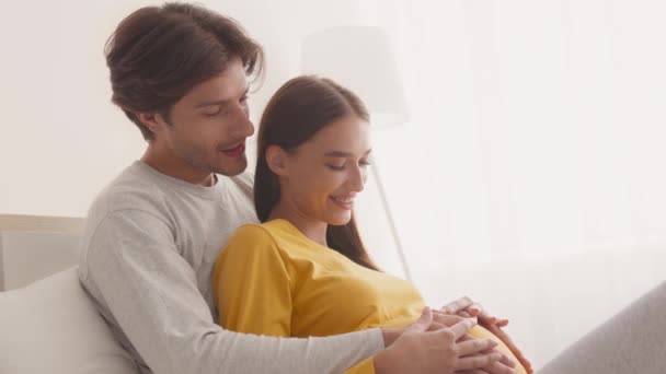 Šťastný čas na očekávání. Detailní záběr portrét potěšený mladý manželský pár těší těhotenství, objímání spolu — Stock video