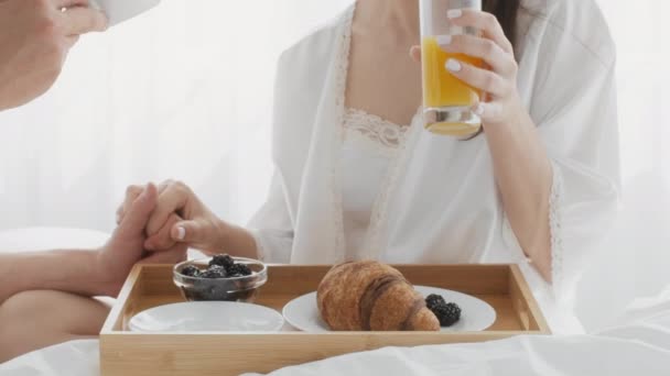 Romantic Couple Having Breakfast And Holding Hands While Relaxing In Bed Together — Stock Video