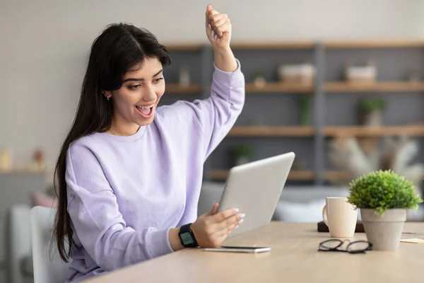 Excited lady using tablet celebrating win shaking fist — Stock Photo, Image