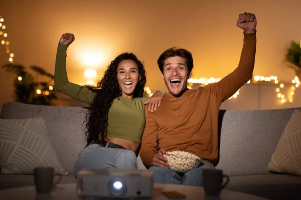 Ζευγάρι βλέποντας αθλητικό παιχνίδι στην τηλεόραση gesturing Ναι στο σπίτι — Φωτογραφία Αρχείου
