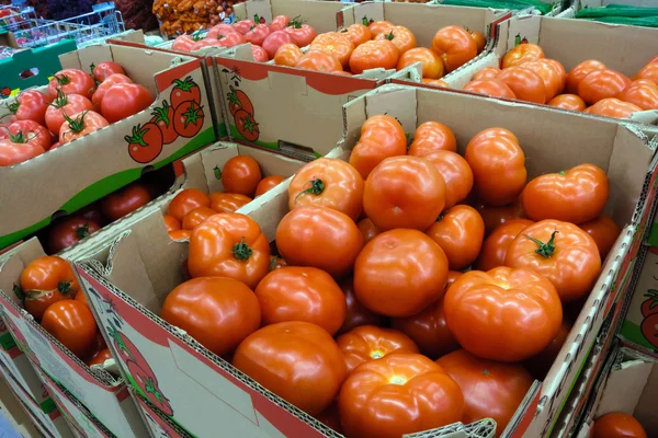 Tomatoes in the boxes at the food store — Stock Photo, Image