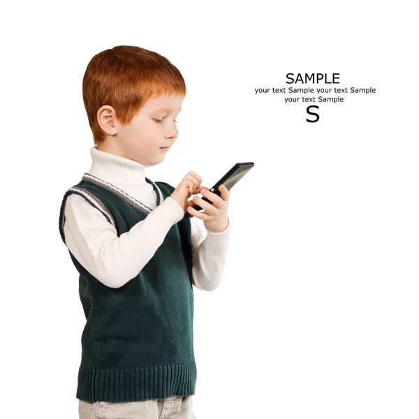 Niedliche rothaarige Kind steht und schaut auf das Smartphone. isoliert — Stockfoto