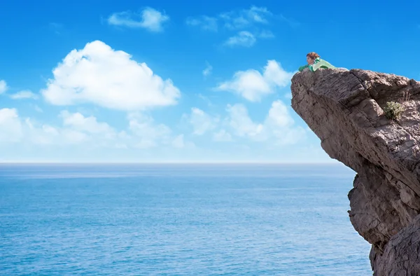 Young slim lonely woman laying at the edge of mountain cliff — Stock Photo, Image