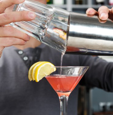 Barmen karıştırma cosmopolitan kokteyl eller