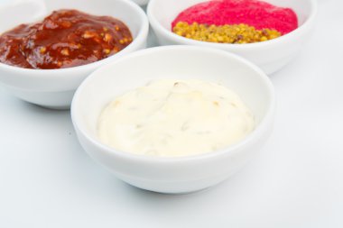 Closeup of sauces in white bowls clipart
