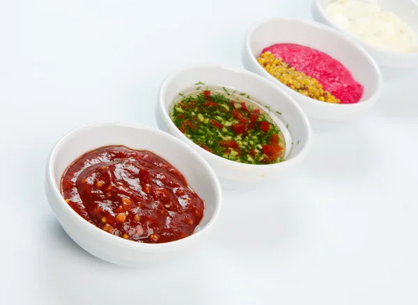 Variety of sauces in white bowls — Stock Photo, Image