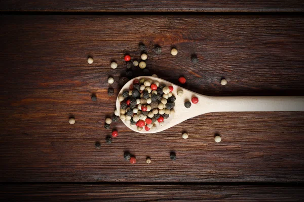 Mix of pepper seasoning in a wooden spoon