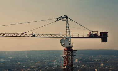 Tower crane silhouette at construction area clipart
