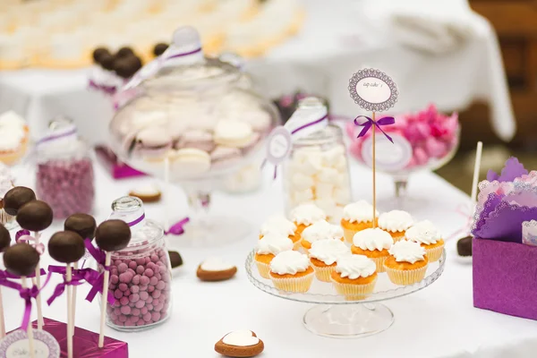 Servido mesa de bar de doces festivos com cupcakes — Fotografia de Stock