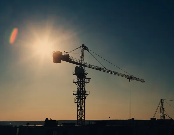 Torre guindaste silhueta na área de construção — Fotografia de Stock